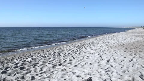 Lonely sandy beach on the baltic coast. Blue sky, bright sun. Small sea waves. Stock Footage 155096728