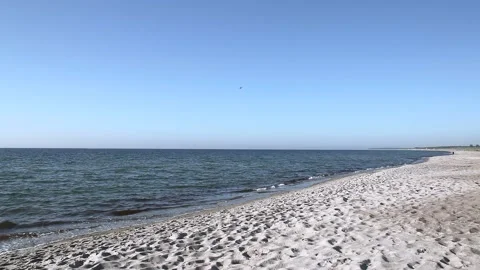 Lonely sandy beach on the baltic coast. Blue sky, bright sun. Small sea waves. Stock Footage 155098287