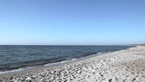 Lonely sandy beach on the baltic coast. Blue sky, bright sun. Small sea waves. Stock Footage 155098290