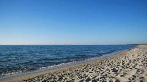 Lonely sandy beach on the baltic coast. Blue sky, bright sun. Small sea waves. Stock Footage 155280199