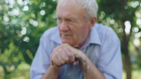 Lonely senior smiling through the worring in the garden 4K Stock Footage 80946579