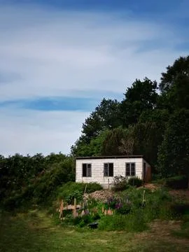 Lonely shed on hill side on cloudy summer day Stock Photos