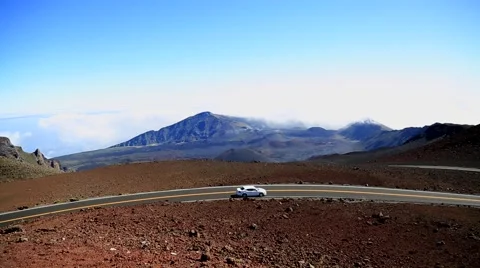 Lonely small car driving mountain road, volcanic landscape, Hawaii Stock Footage 57403098