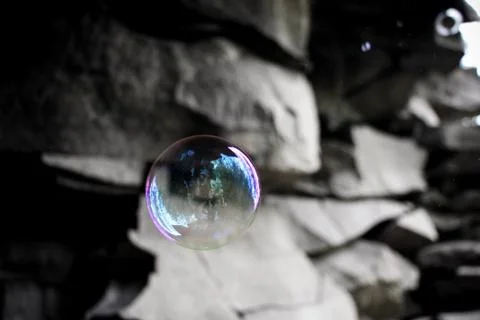 A lonely soap bubble against the background of the rock. Stock Photos