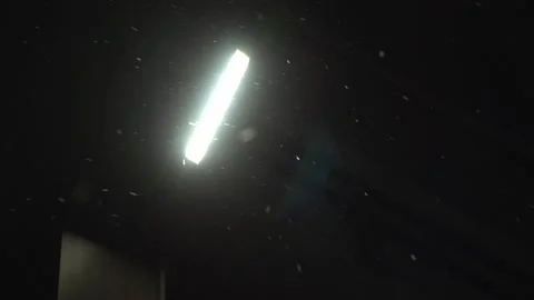 Lonely street light on the wall with weak light leak in night when snowing Stock Footage 166558039