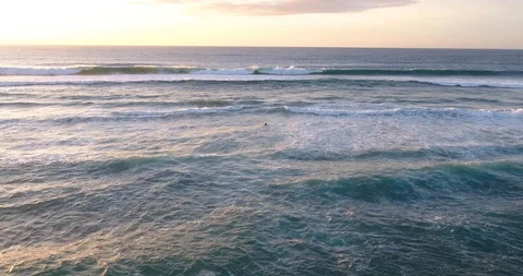 Lonely Surfer Paddling under the waves in Guincho Beach Portugal Aerial push in 動画素材 87391744