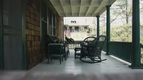 Lonely Swing Rocks Gently in an Empty Back Porch Stock Footage 53080084