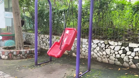 Lonely swing swinging in the wind without people Le Thi Rieng park Stock Footage 219290200
