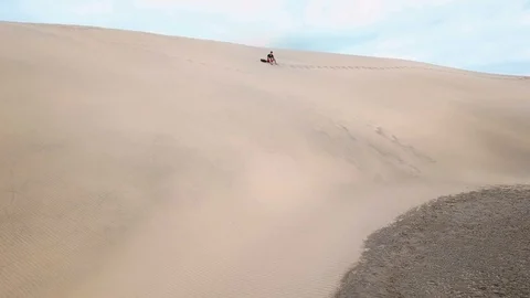A lonely traveler is resting while sitting on a sand in a desert in summer day Stock Footage 95713625