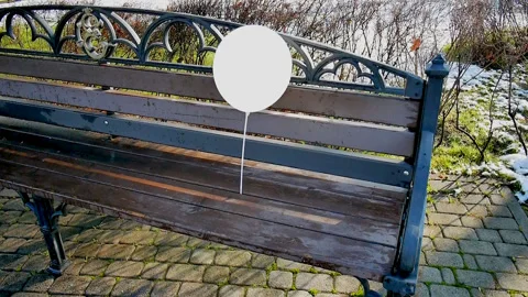 Lonely white balloon, left on a bench outside, swaying in the wind Stock Footage 85660752