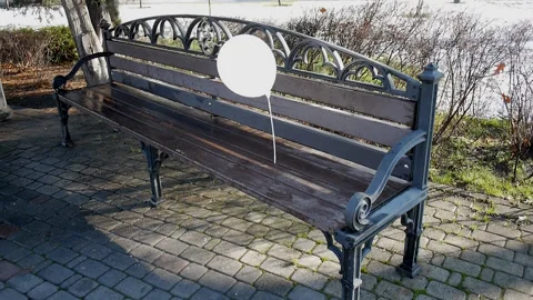 Lonely white balloon, left on a bench outside, swaying in the wind Stock Footage 85660988
