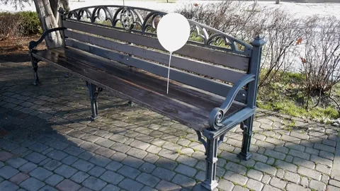 Lonely white balloon, left on a bench outside, swaying in the wind Stock Footage 85661102