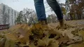 Lonely woman walking through autumn park, throwing up fallen golden leaves HD Footage