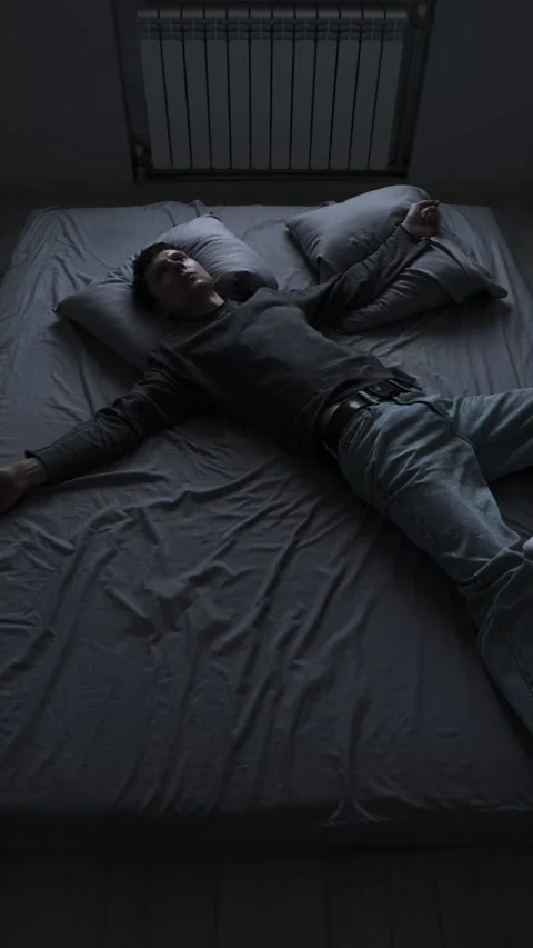 Lonely young man lying alone on bed feeling empty and depressed after breakup or Video stock 313879171