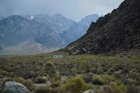 Lonesome trailer in front of mountain range Stock Photos