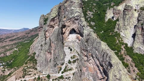 Long Aerial Approach Toward Ancient Cliffside Stone Structure in Mountain Stock-Footage 339465407