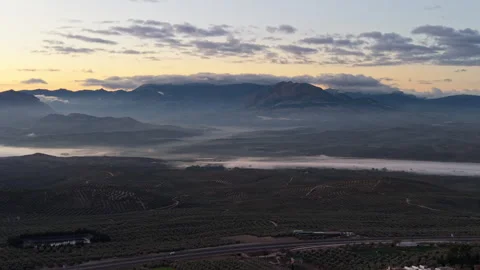 Long Aerial Shot of Cloud-Covered Sierra Nevada with Olive Fields in the Front 動画素材 311476036