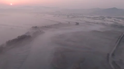 Long Aerial Take Over Winding River Blanketed in Dawn Fog With City Lights Stock Footage 344523257
