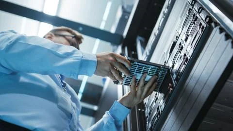 Long Angle Shot In Fully Working Data Center of IT Engineer Installing Hard D Stock Photos