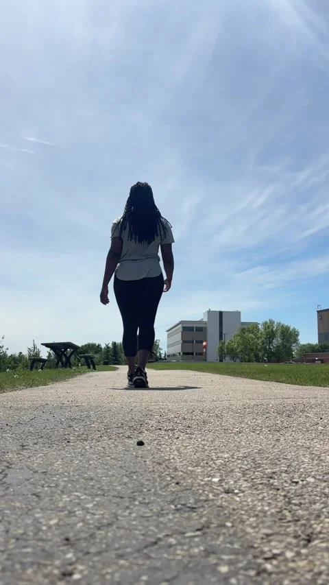 Long angle view of a Black person walking on a path Stock Footage 337849015