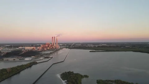 A long approach towards a coal fired power plant with steam billowing Stock Footage 161204427