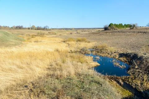 Long-awaited spring creeks flow over ravines and hills on a sunny day. Water  Stock Photos