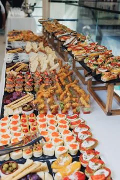 Long banquet table holds assorted appetizers Foto stock