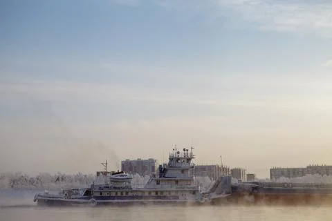 Long barge going down river in cold winter. Stock Photos