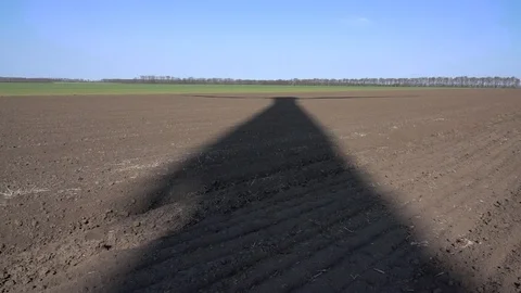 The long black shadow of a rotating wind turbine on the ground. Vídeos de archivo 105873412