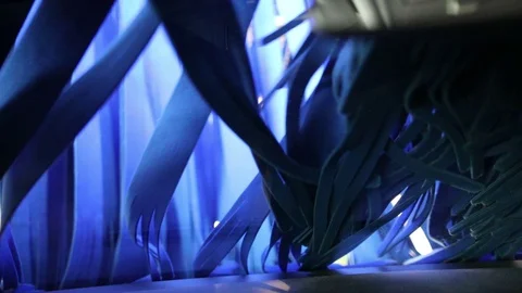 Long blue ribbons move in front of the windshield of the car in the car wash Stock Footage 129709439