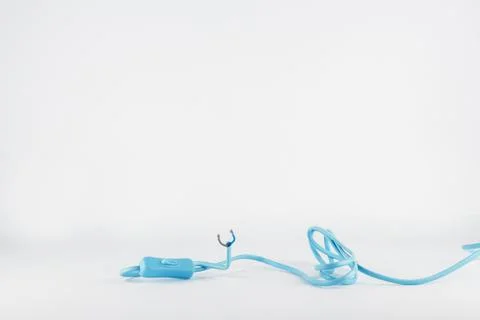 Long blue tangled electrical wire with a plastic switch on white background Stock Photos