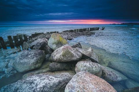Long breakwater at cloudy sunset Stock Photos