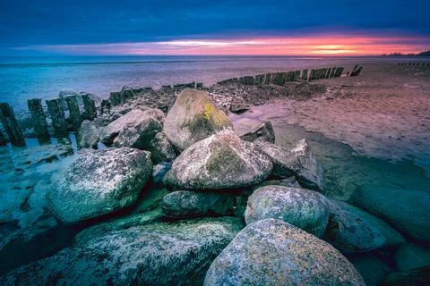 Long breakwater at cloudy sunset Stock Photos