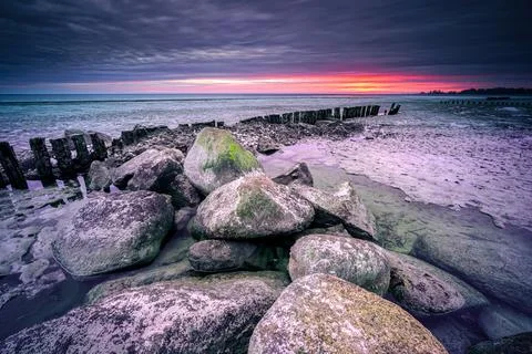 Long breakwater at cloudy sunset Stock Photos
