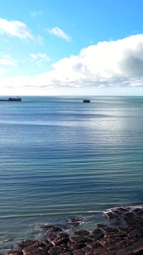 Long breakwater orbit to side view near Boulogne-sur-Mer, vertical Stock Footage 347178947