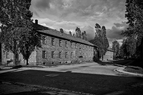 Long brick barracks under dramatic sky at Auschwitz museum Stock Photos
