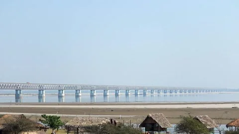 Long bridge over river with huts in foreground Stock Footage 331277555