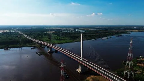 Long bridge spans wide river under clear blue sky Stock-Fotos