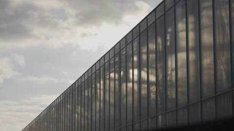 A long building with a cloudy sky in the background Stock Footage 297843901