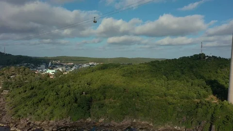 Long cable car above mountain on island in sunset and old fishing town below un Stock Footage 124367021