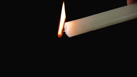 Long candle on a dark background. Vídeo Stock 107780897