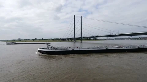 Long cargo ships floating slowly in the water near the Oberkasseler Bridge Stock Footage 157314352
