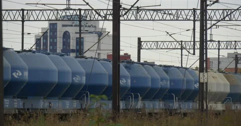Long Cargo Train Stands On The Railway Track Tall White-Blue Building On The Stock Footage 54843022