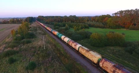 Long cargo train transporting wagons across the autumn forest and fields - 7 Stock Footage 80484014