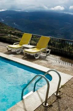 Long chairs by the pool 3 Stock Photos