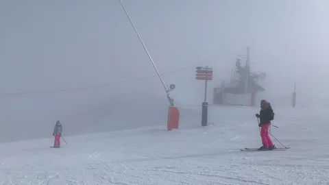 Long clip, skiing down snowy grey mountain, 3 skiers, handheld, French Alps Stock Footage 104169288
