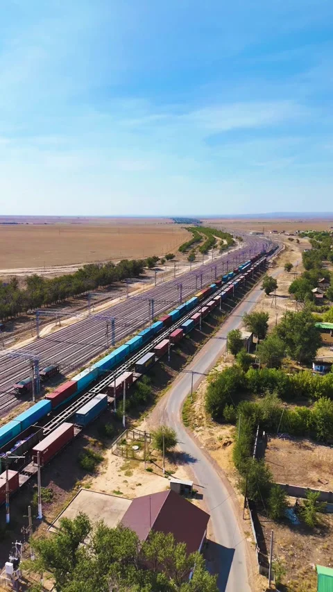 Long Container Train Moving Through Curved Railway Yard Near Road Stock Footage 346320836