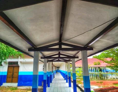 Long corridor awning structure with exposed wooden roof truss connecting bu.. Stock Photos