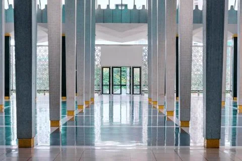 Long corridor between many columns with open doors in the end Stock Photos