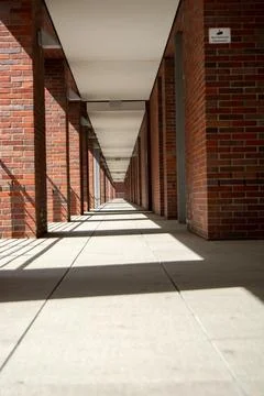 Long corridor with brick columns and shadows Stock Photos